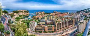 Prince’s Palace in Monaco above Port Hercule with Monegasque flags on buildings